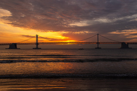 A bridge across the sea and a beach sunrise