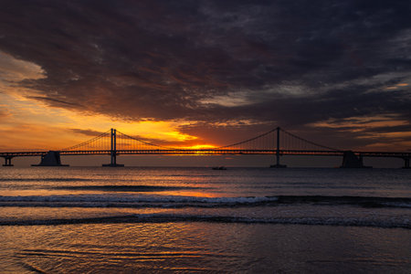 a bridge across the sea and a spectacular sunrise in koreaの写真素材