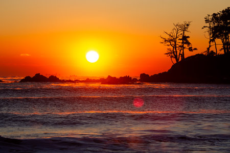 The silhouette of the island with trees and the sunrise of the sea foggingの写真素材