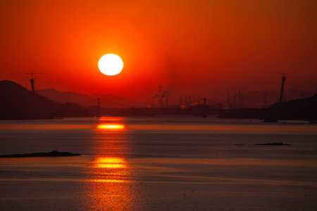 a view of a sea sunset with a silhouette of a bridgeの写真素材