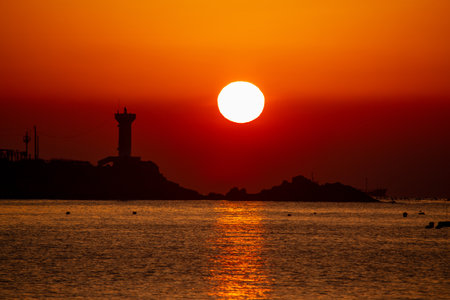 sunrise view of the sea with a lighthouseの写真素材