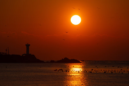sunrise view of the sea with a lighthouseの写真素材
