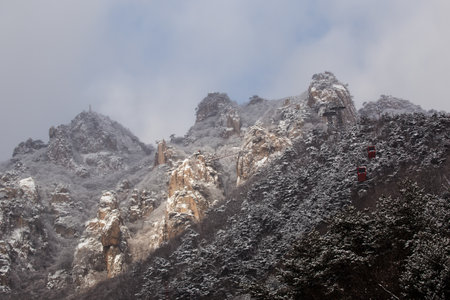 Winter scenery with snow-covered rocky mountains and cable carsの写真素材