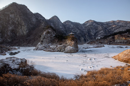 Winter scenery with frozen rivers, pavilions on rocks, and snow-covered mountains
