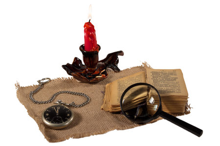 Book candle watch magnifier match tablecloth old round flame fire text still life isolated white...