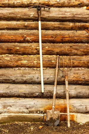 Garden tools on a background of rustic wooden wall of the barn