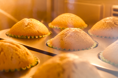 Closeup banana muffins baking in the hot ovenの写真素材