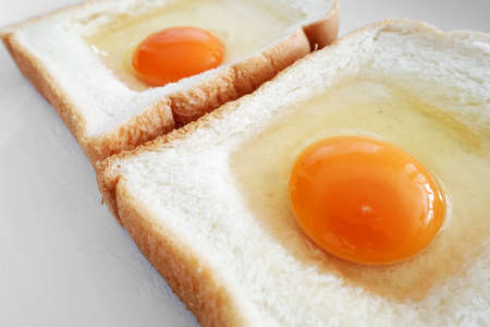 Raw egg on white bread before cookの写真素材
