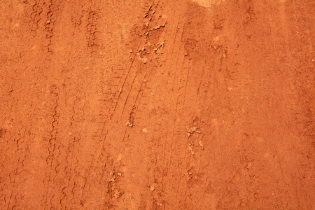 Wheel tracks on red soil rural road backgroundの写真素材