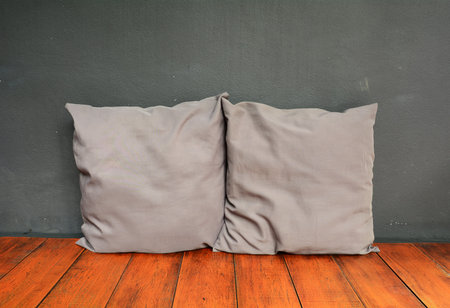Two gray pillow on wood bench