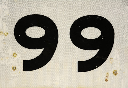 Close up of number ninety-nine black lettering on a white background