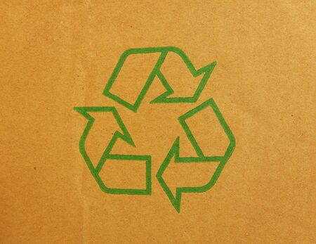 Green recycle symbol on cardboard backgroundの写真素材