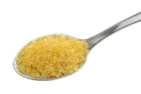Brown sugar in a silver spoon on white backgroundの写真素材