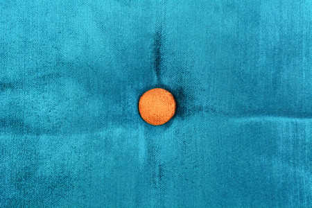 Gold button on blue fabric texture backgroundの写真素材