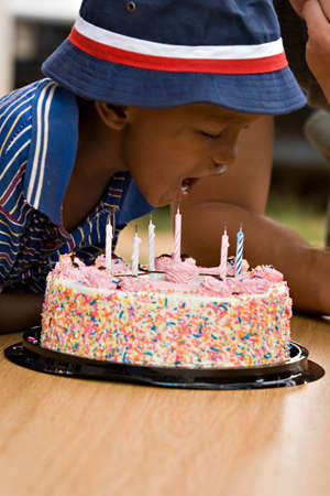 Happy African American boy with a cake on his birthday