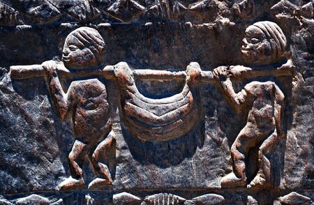 Vintage wooden bas-relief traditional african  hunters carry animal の写真素材