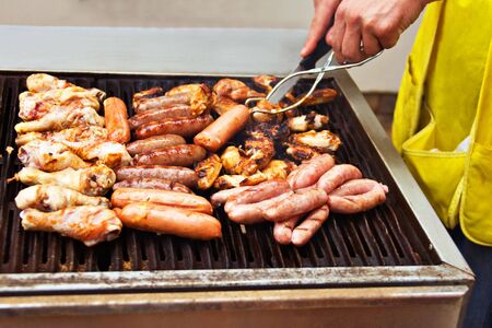 mixed barbecue sausage and chicken , Caucasian man cooking