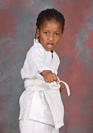Small karate girl training , on colorful  backgroundの写真素材