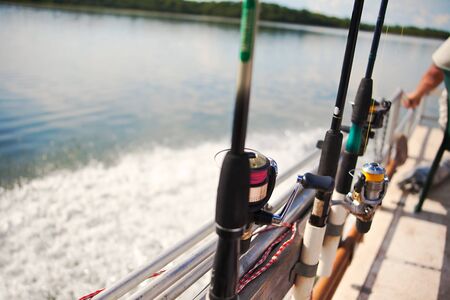fisherman in a boat on Zambezi river, Africa, fishing rods with the reelの写真素材