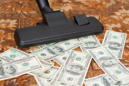 Collecting by a vacuum cleaner from a floor of moneyの写真素材