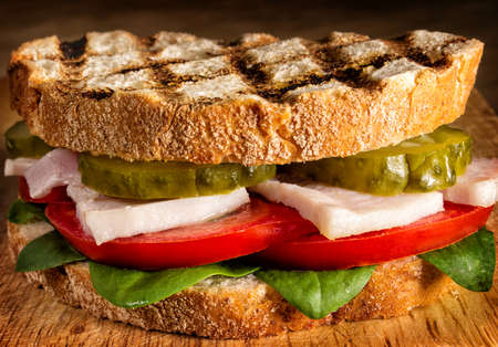 Sandwich with chicken, tomatoes and pickles close upの写真素材