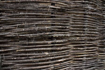 stale old wicker fence made of willow twigsの写真素材