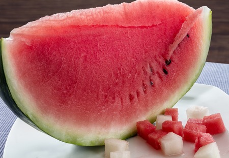 Cut watermelon on a white plate with slices of melon and watermelonの写真素材