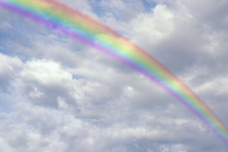 a bright rainbow in front of some clouds