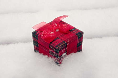 a gift box sitting out in the white fluffy snowの写真素材