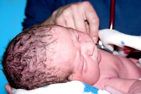 a newborn baby having its heart rate takenの写真素材