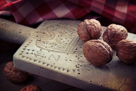 Wooden ancient cutting board with walnuts