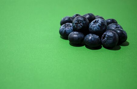 handful of blueberries on a green backgroundの写真素材