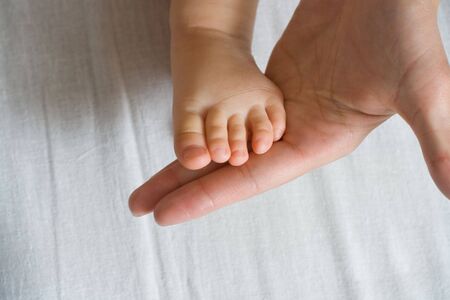mother is holding her  small foot