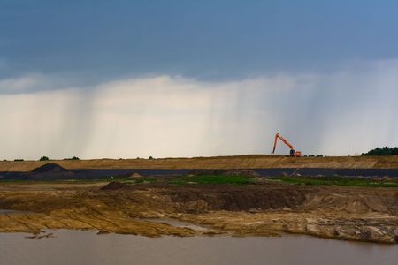 red excavator against a background rainy skyの写真素材