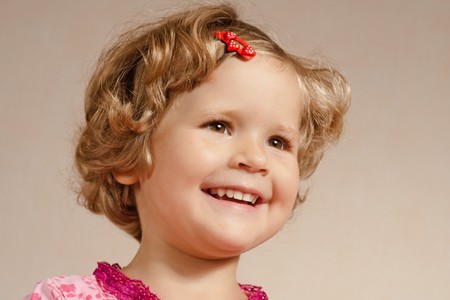 Smiling pretty young girl with a red hair-pin