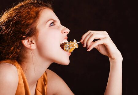 Young pretty girl eating a yellow candy