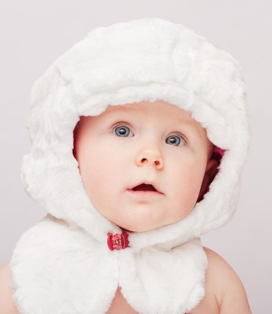 Small cute surprised child in white hatの写真素材