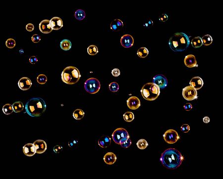 Numerous colorful soap bubbles on black background