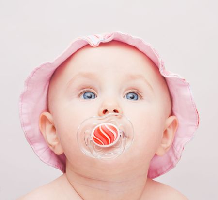 Small baby with pink hat and dummy