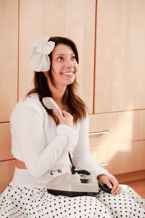 Young pretty girl holding phone receiverの写真素材