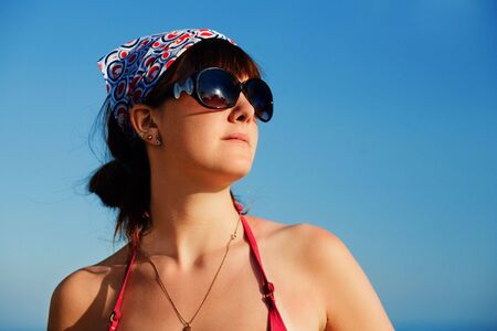 Young girl in sunglasses against blue sky