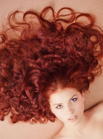 Young beautiful girl with long hair lying on the floorの写真素材