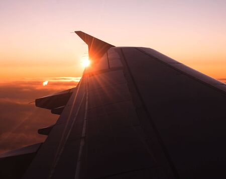 Plain wing against sunset orange skyの写真素材