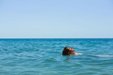 Swimming girl in the blue seaの写真素材