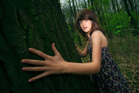 Young pretty frightened girl in the forestの写真素材