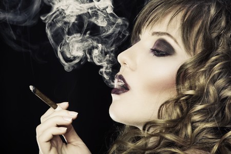 Young pretty girl is smoking cigaretteの写真素材