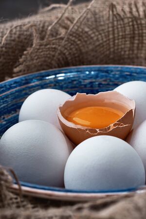 Ecological natural fresh eggs collected in the plate for cooking on the fabric.