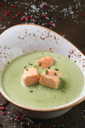 Cream of spinach soup with salmon for lunch. Spilled salt and pepperの写真素材
