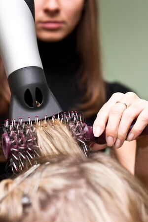 Hairdresser dries the hair in a beauty salonの写真素材