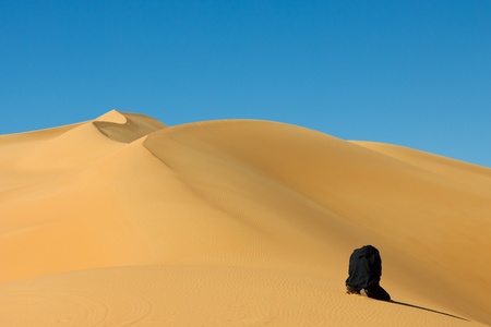 Muslim man praying in the desert - Awbari Sand Sea, Sahara Desert, Libyaの写真素材